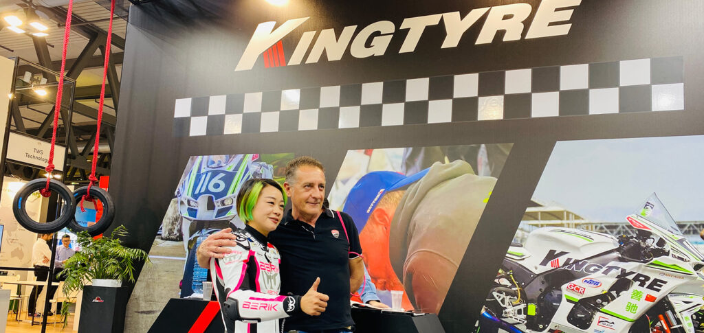 Visitors testing Kingtyre motorcycle tires at an interactive booth during EICMA 2024