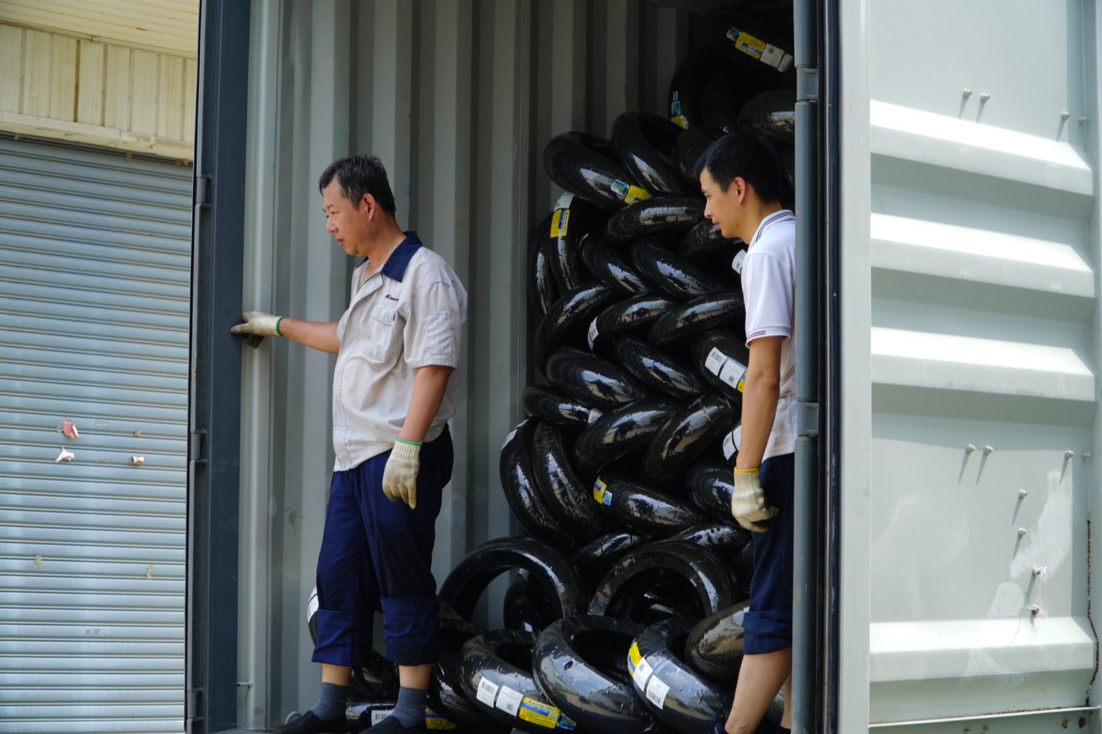 Quality control inspector measuring motorcycle tire dimensions during pre-shipment inspection at a Chinese tire factory